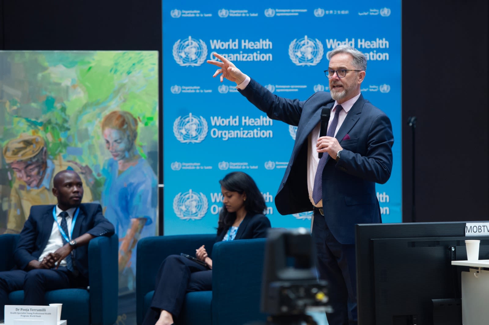 Jim Campbell addressing people in front of a World Health Organization sign