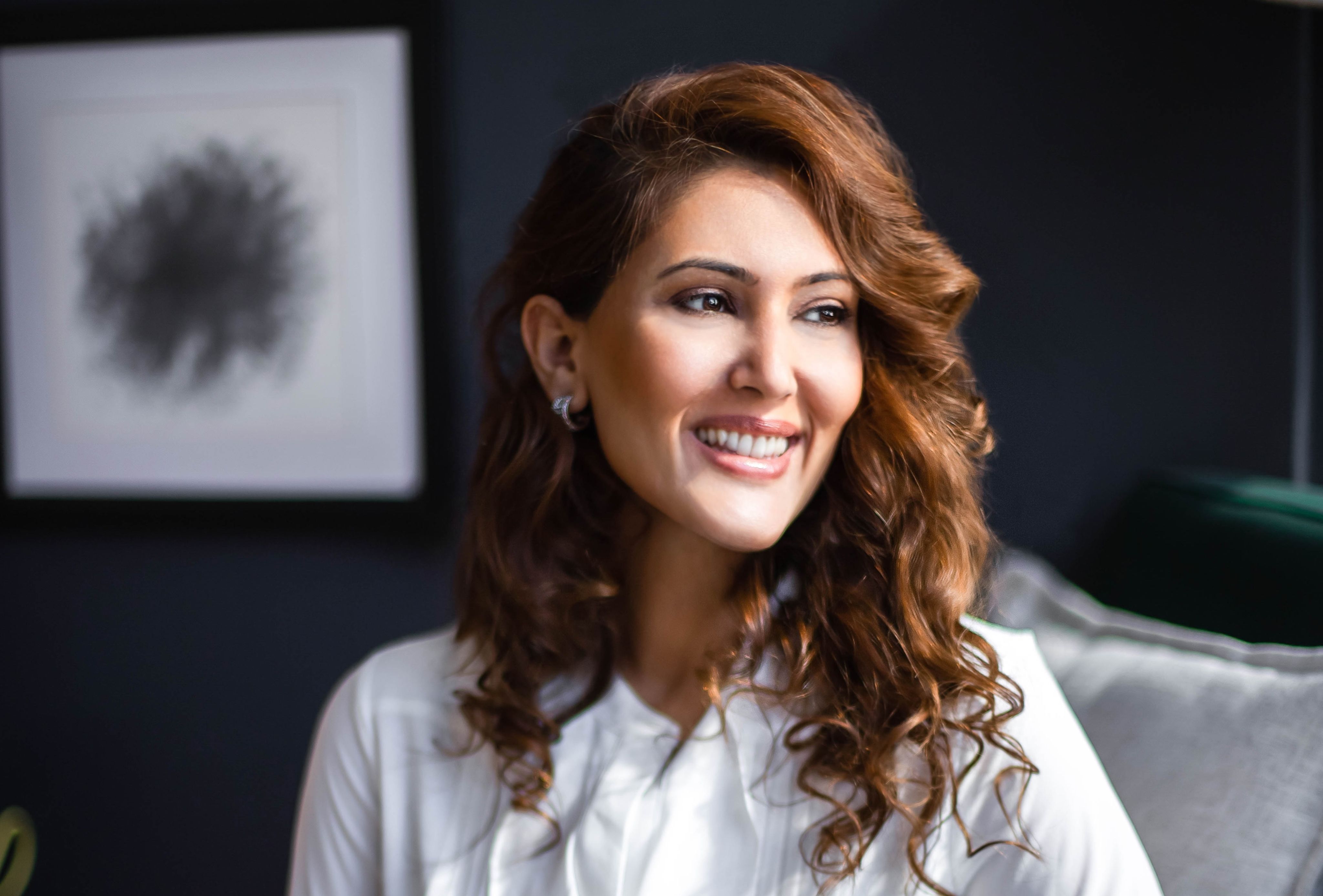 Photo of Anu Shah smiling and looking to her left.