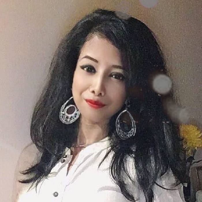 Photo of Somdutta Sarkar wearing a white shirt and large hooped earrings
