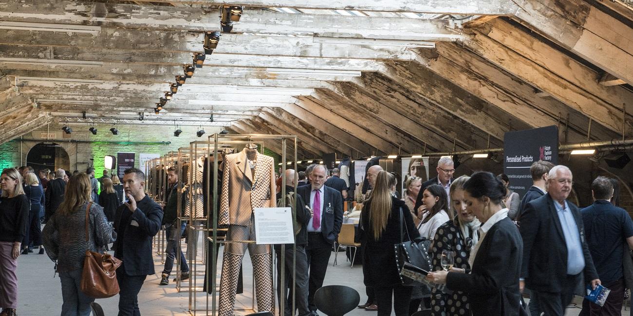 Groups of guests standing and chatting among fashion displays.