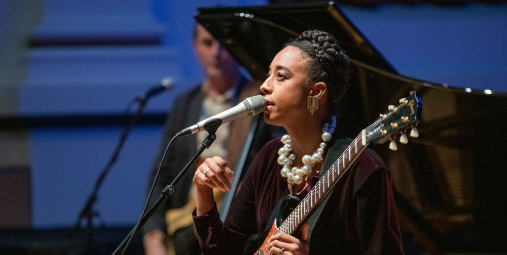 Corinne Bailey Rae performs on stage with a guitar