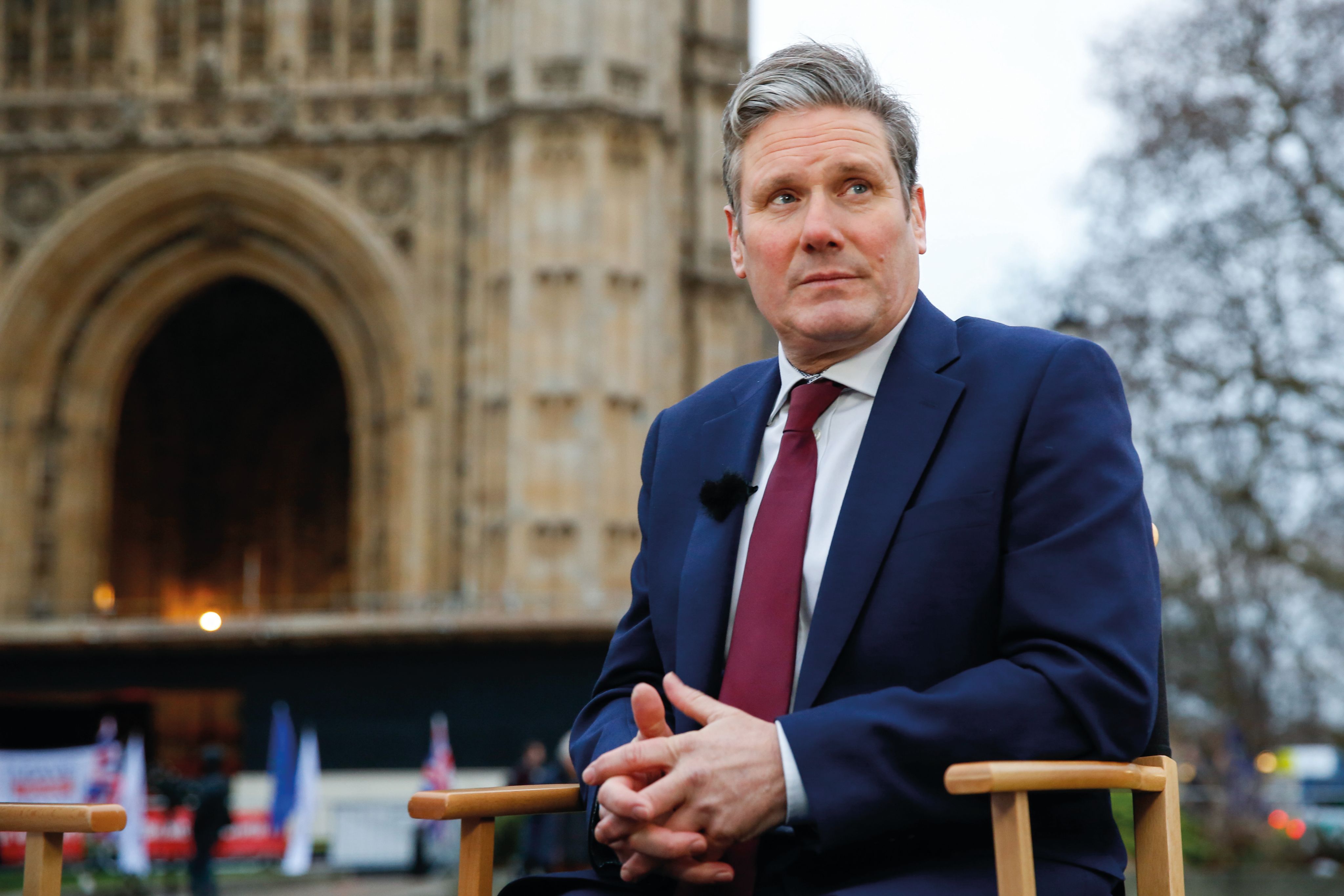 Keir Starmer sat on a chair in front of the Houses of Parliament