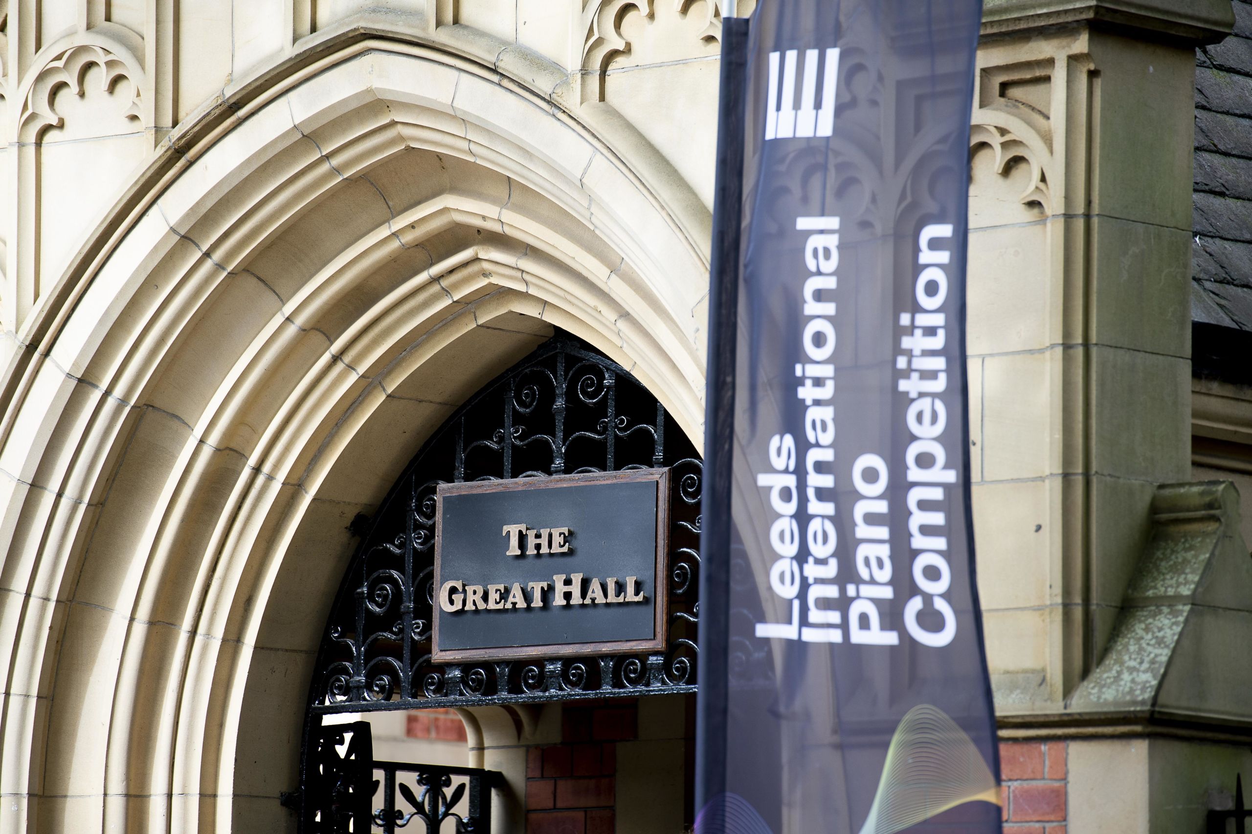 Entrance to The Great Hall. A sign above reads 'The Great Hall' and a tall flag reads 'Leeds International Piano Competition'.