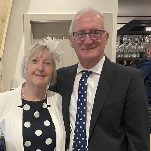 A man and a woman dressed smart and smiling for the camera