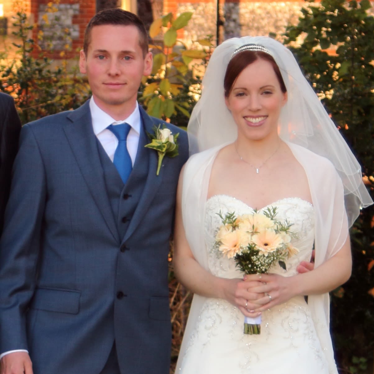 A man and woman on their wedding day. the woman is holding a bouquet of flowers