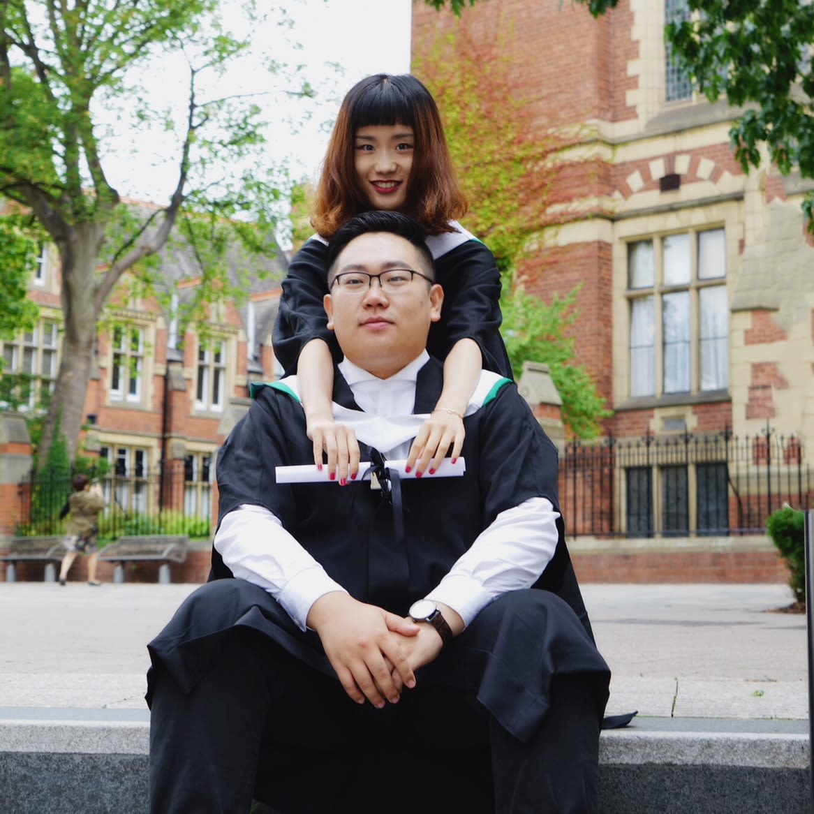 A man and a woman embracing outside the great hall.