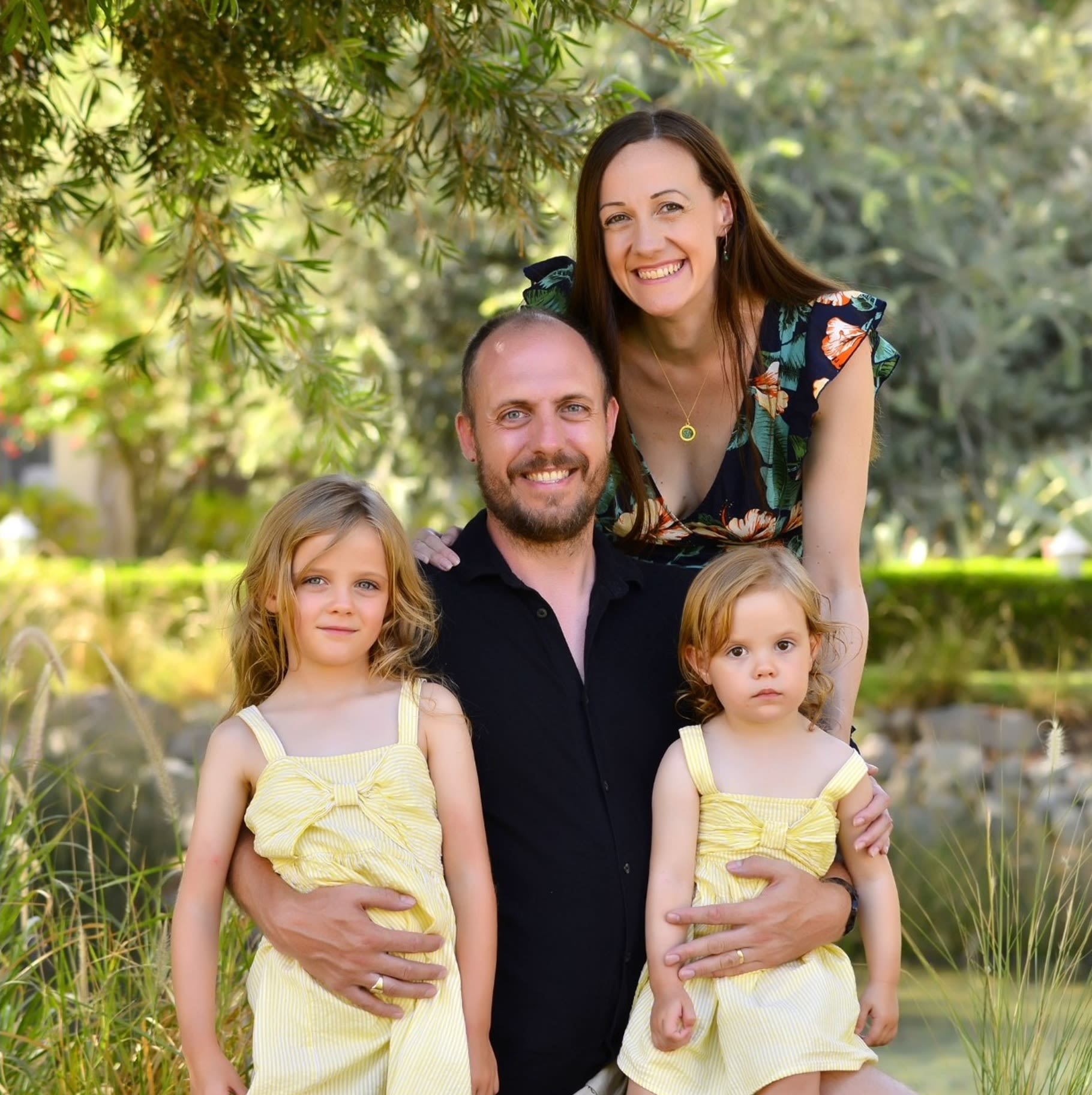 A man and a woman smile for a photo with two young girls