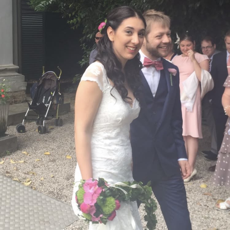 A man and woman on their wedding day. The woman is holding a bouquet of flowers