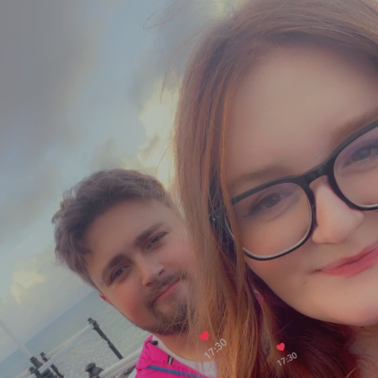 A man and woman smile to the camera for a selfie