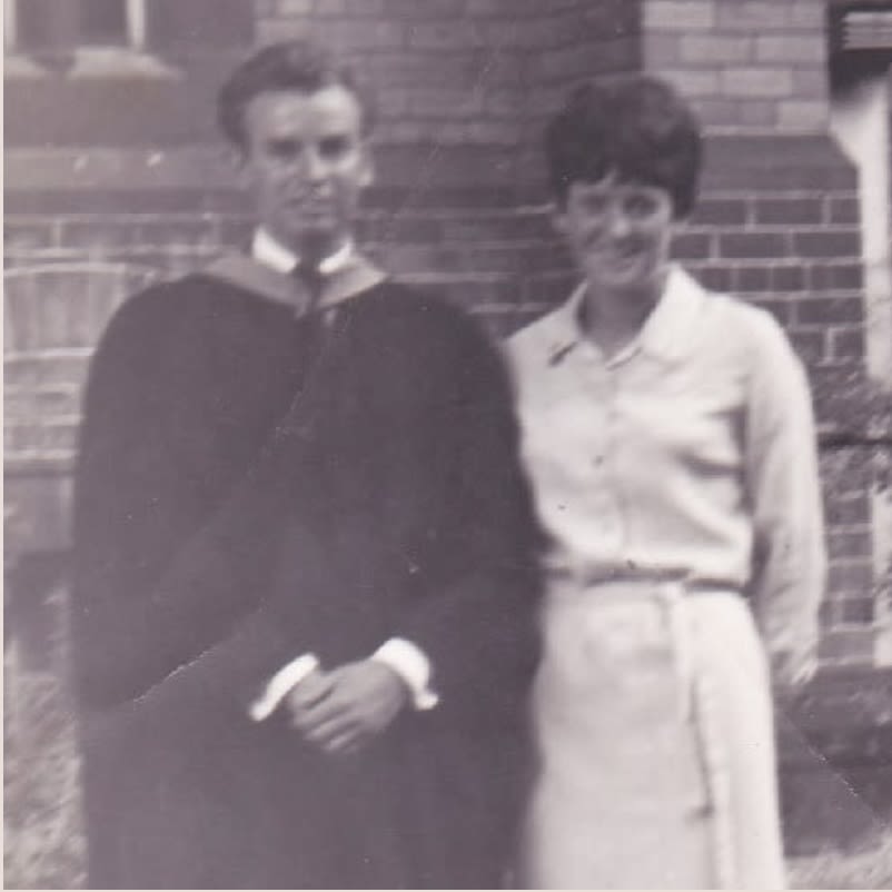An old black and white photo of a man and woman.The man is dressed in Leeds graduation gown