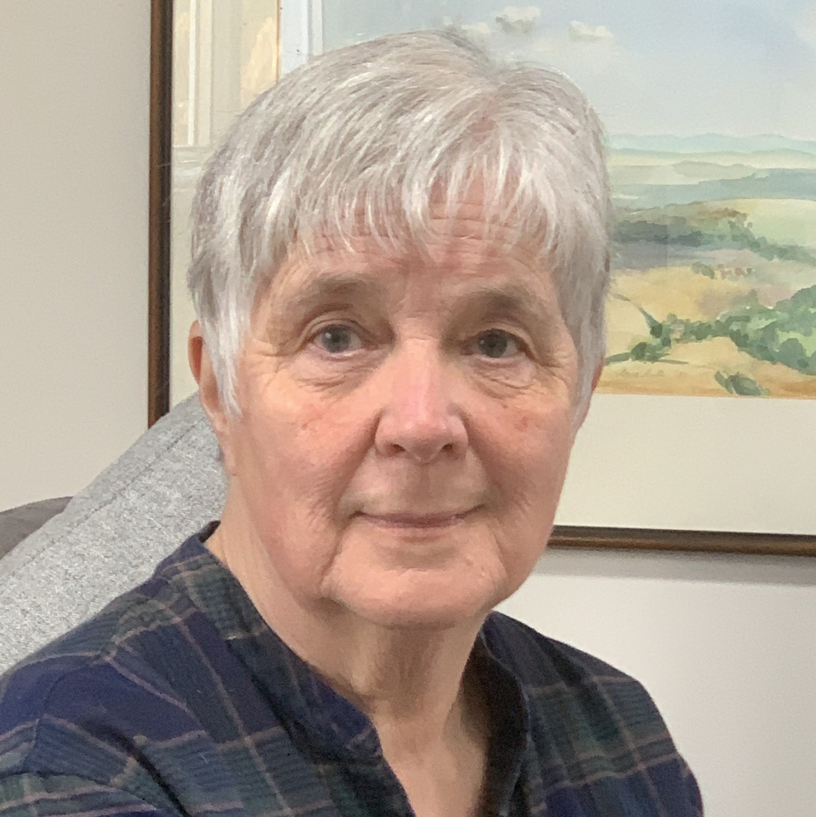 A photo of a woman with short hair smiling at the camera