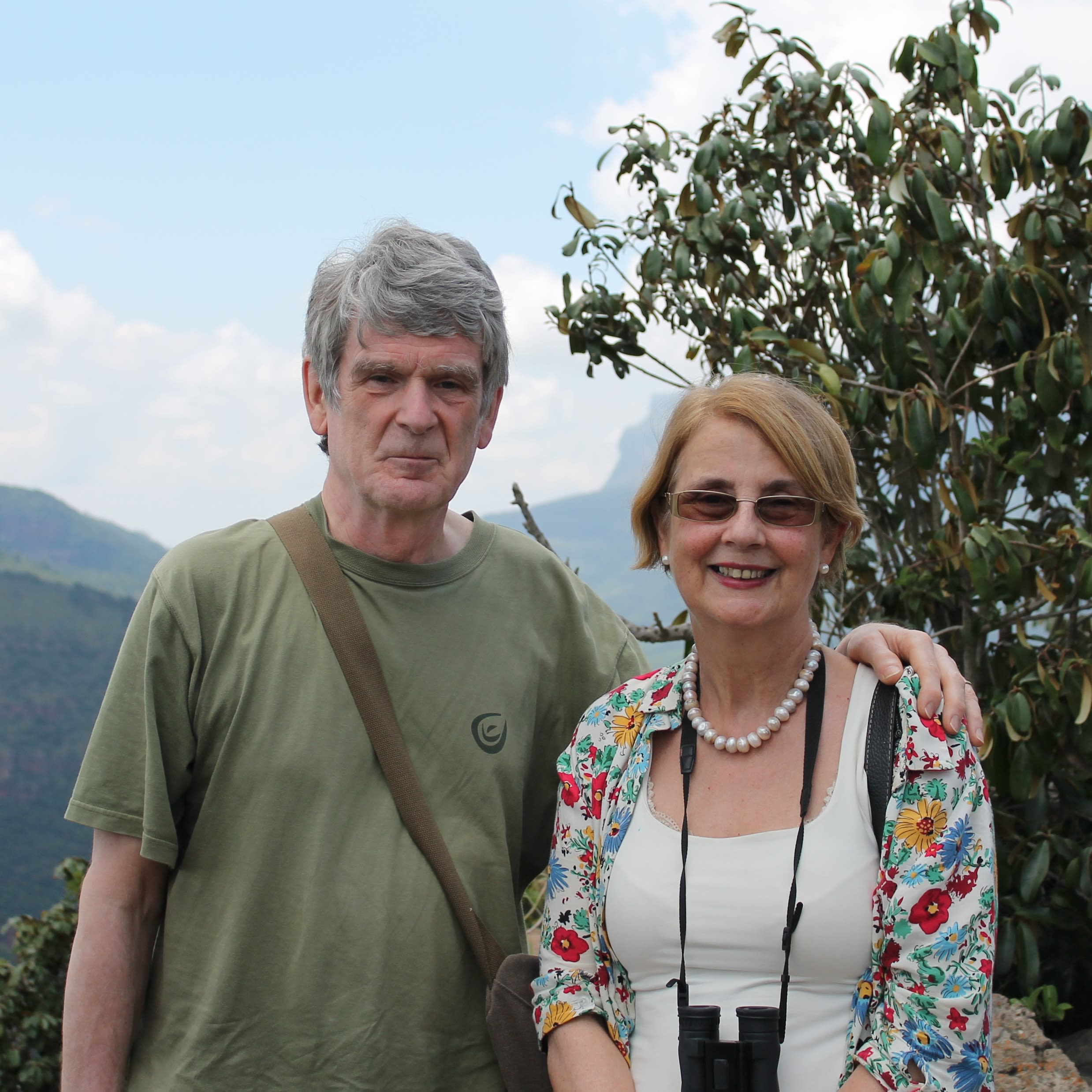 A man and a woman posing for a photo in front of a tree