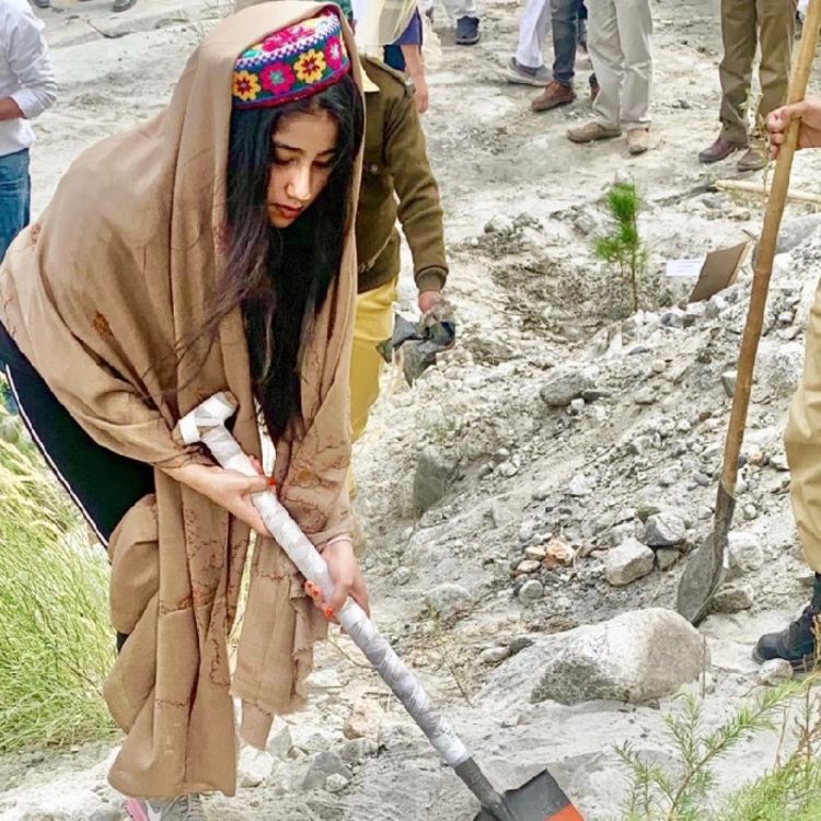 Photo of Sarah Aslam digging with a shovel