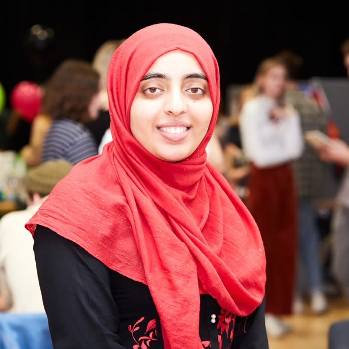 Photo of Aimen Mahmood dressed in red and black