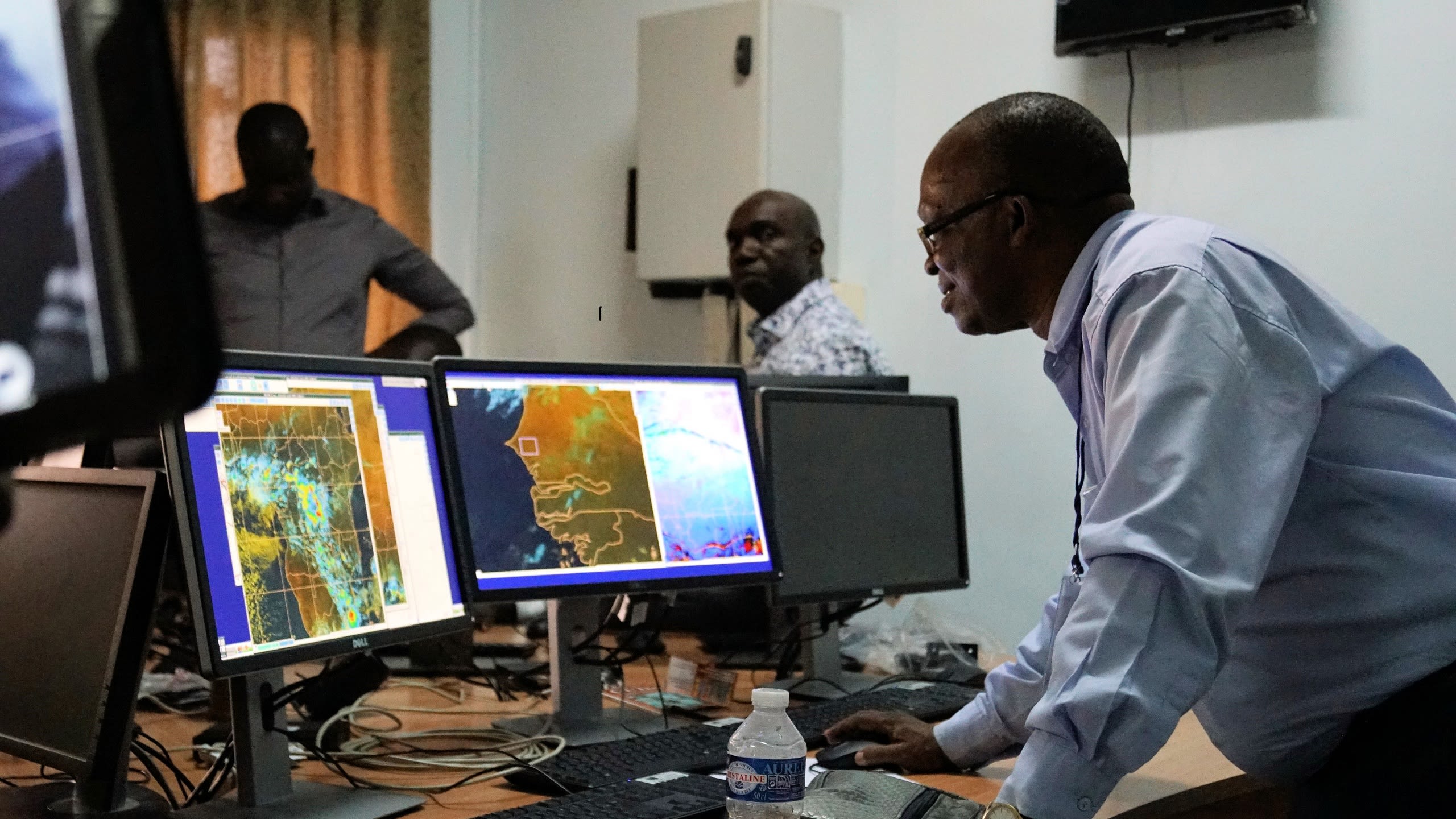 A forecaster looks at screen with the latest weather information