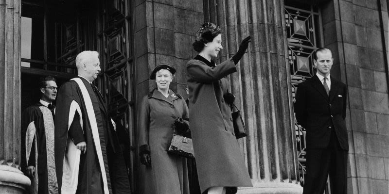 The Queen stands on the Parkinson steps and waves to the crowd
