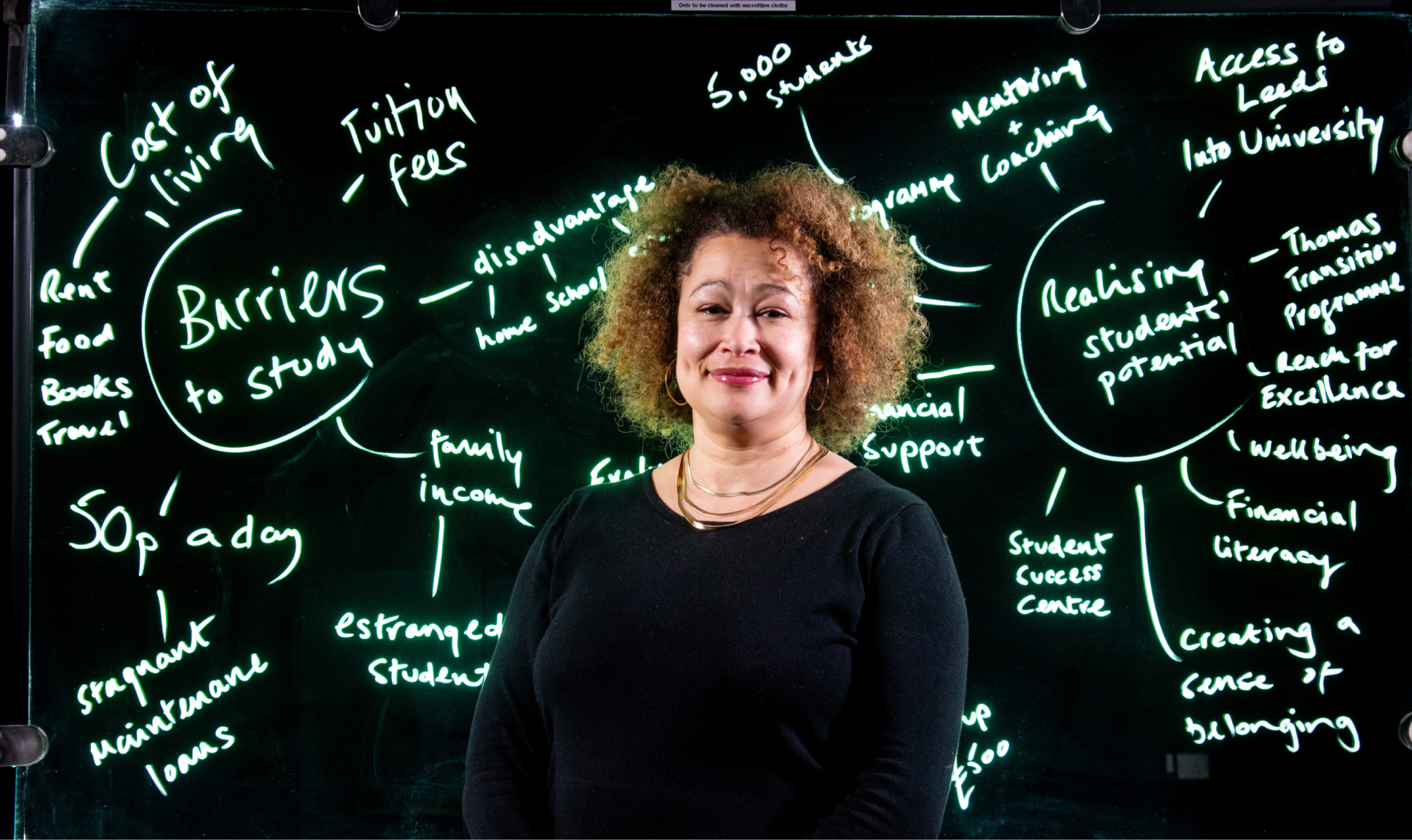Louise Banahene stands in front of an electronic display board