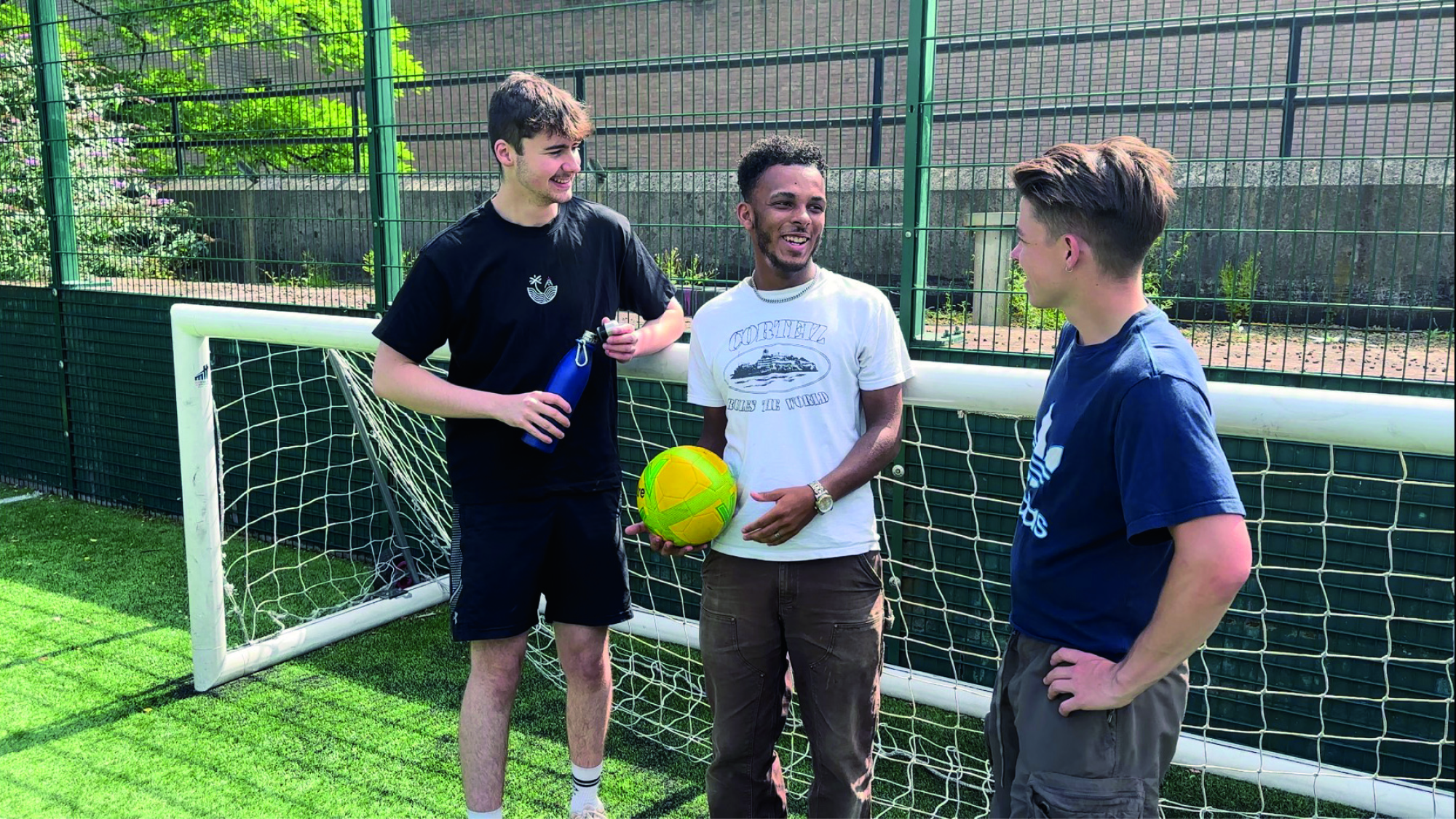 Three students play football