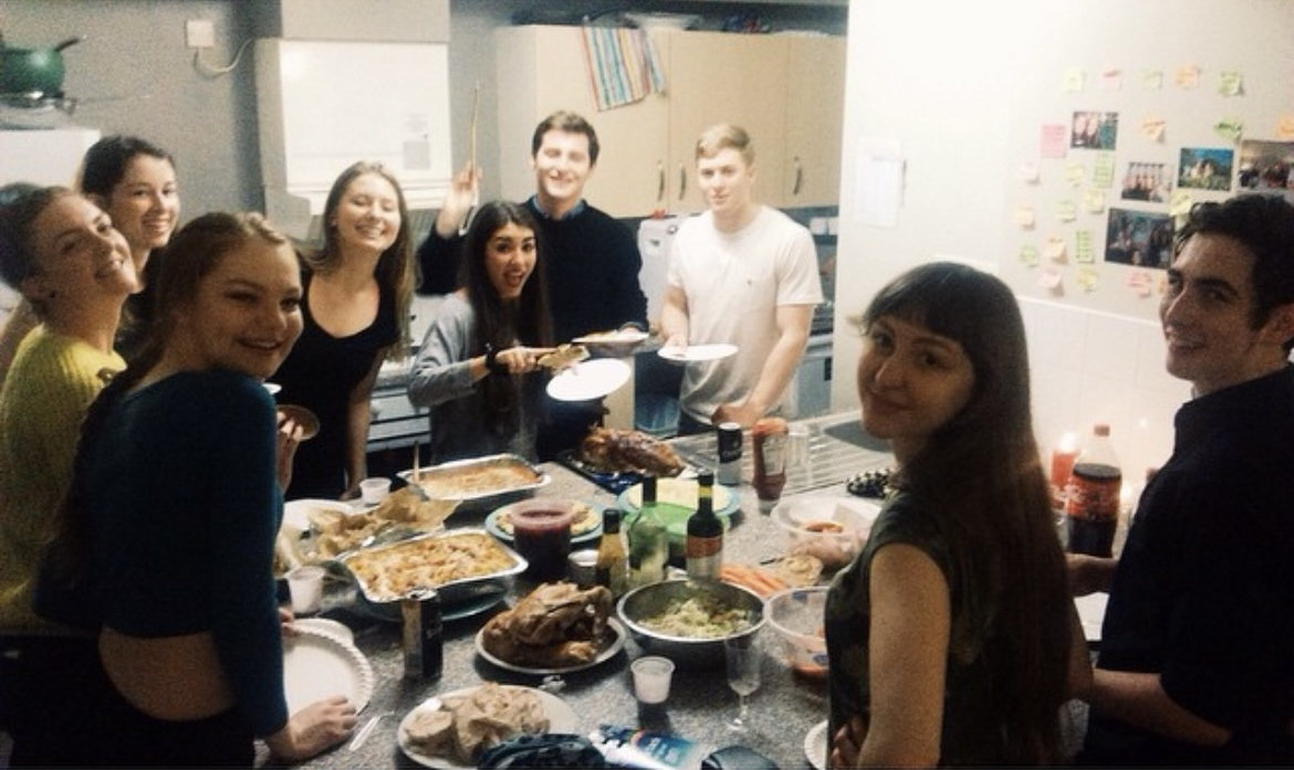 A group of friends choose food from a buffet selection
