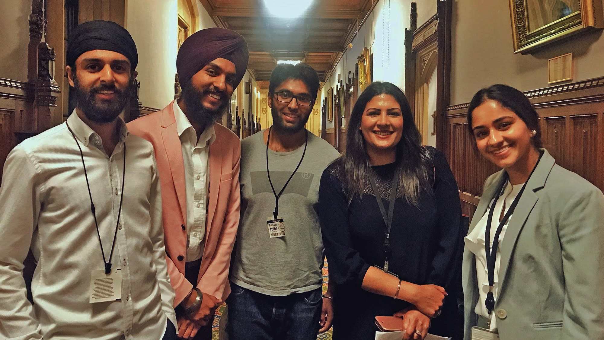 A group of people stood in a corridor smiling at the camera